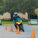 Motorcyclist navigating a training course of traffic cones.